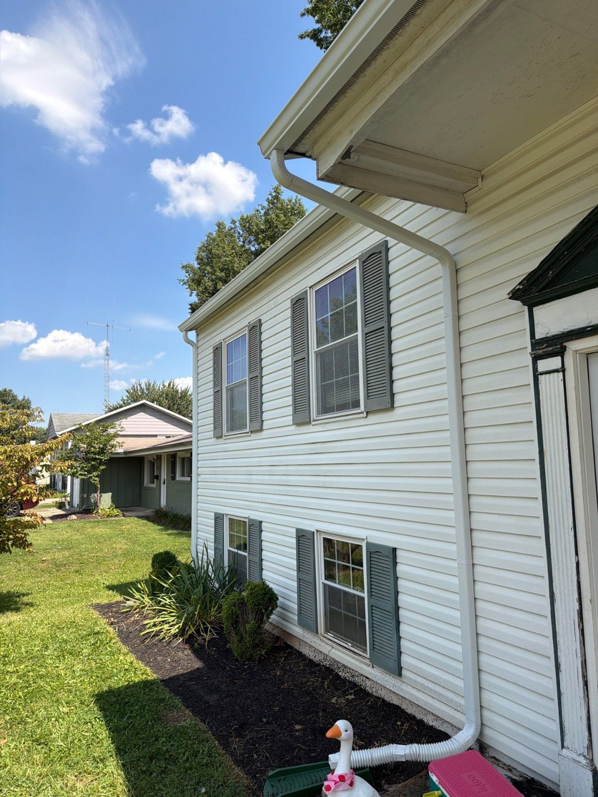 Fresh gutter and 2x3 downspout carrying water clear of the foundation