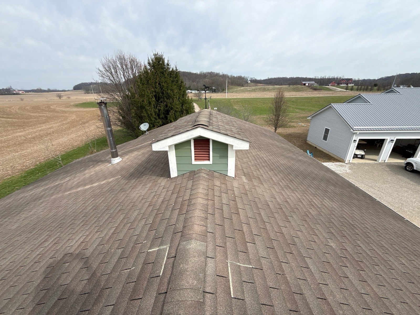 Aging, weather-beaten shingles across the main slopes and dormer