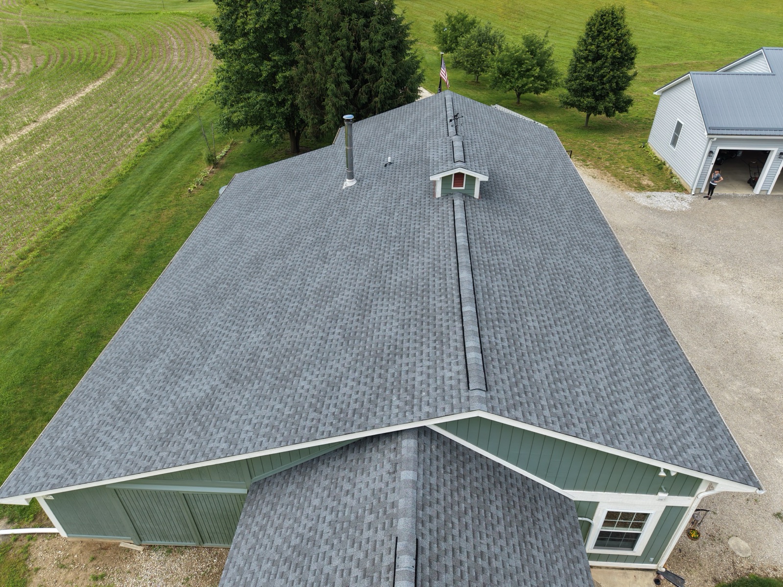 The finished roof — crisp new charcoal architectural shingles and clean hip lines